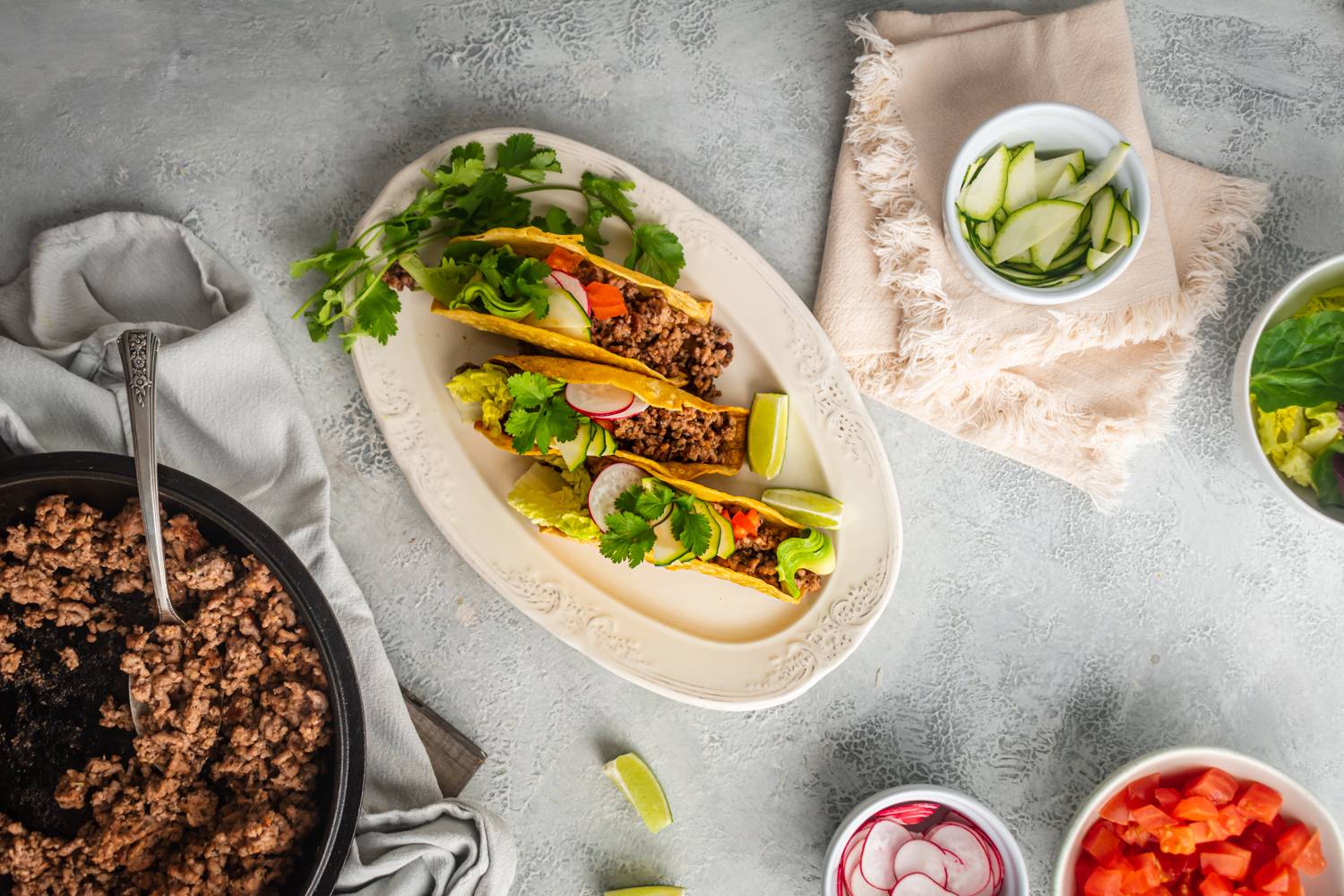 Ground beef tacos with radish, lettuce, and cilantro in crispy taco shells.