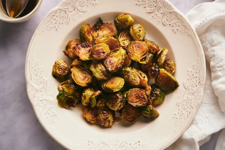 How to Cook Brussel Sprouts (+ 30 Recipe Ideas) Brussel sprouts that have been roasted in a white bowl.