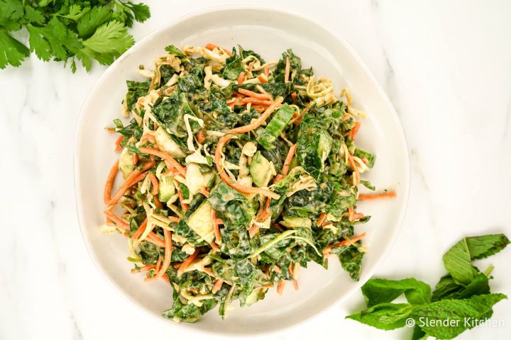 Asian Kale Apple Slaw Asian slaw with kale, apples, and carrots with fresh basil and mint on the side.