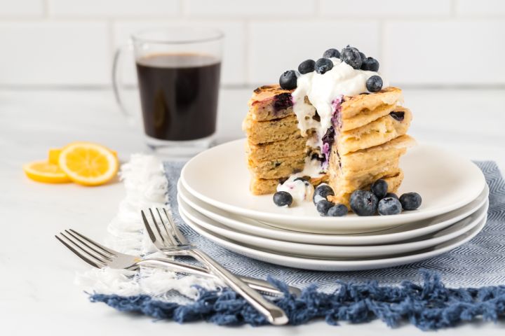 Ricotta Pancakes with Blueberries Blueberry lemon ricotta pancakes in a stack with with fresh blueberries and Greek yogurt.