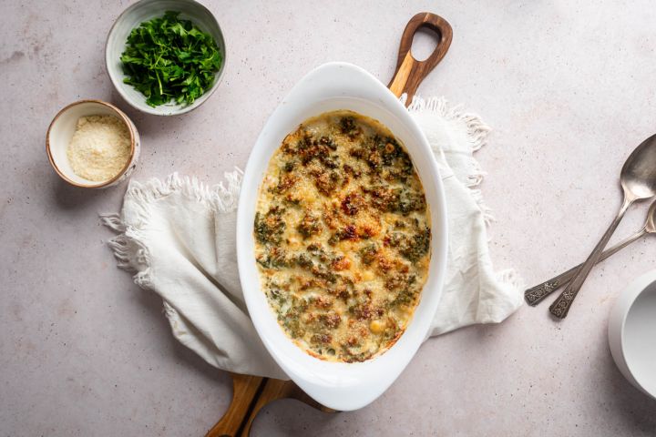 Creamed Kale Creamed kale with tender kale cooked with cream cheese, milk, and Parmesan cheese in a white baking dish,