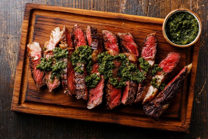 Grilled Sirloin Steak with Chimichurri Grilled sirloin steak on a cutting board with chimichurri.