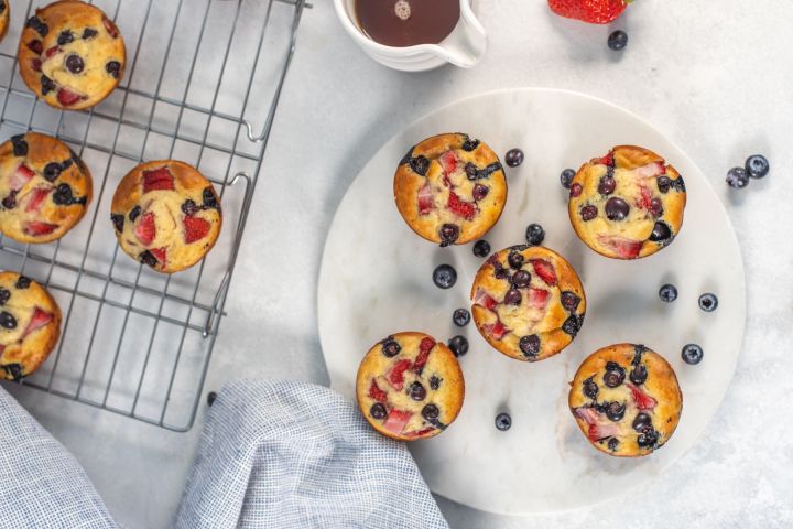 Pancake Muffins Pancake muffins with fresh fruit on a plate with a wire rack on the side.