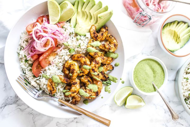 Peruvian Shrimp Bowls Peruvian shrimp rice bowls with grilled shrimp, white rice, cilantro mint sauce, salsa criolla, and sliced avocado.