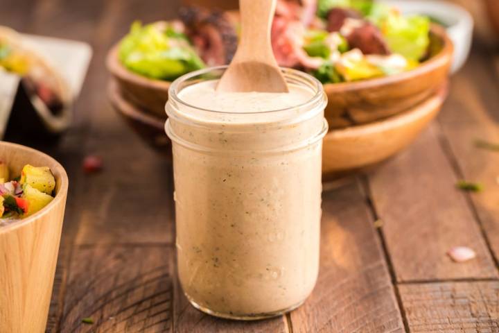 15 Rice Bowl Sauces To Make Your Bowls Even BETTER! Southwest salad dressing in a glass jar with Greek yogurt, lime juice, taco seasoning, and salsa.