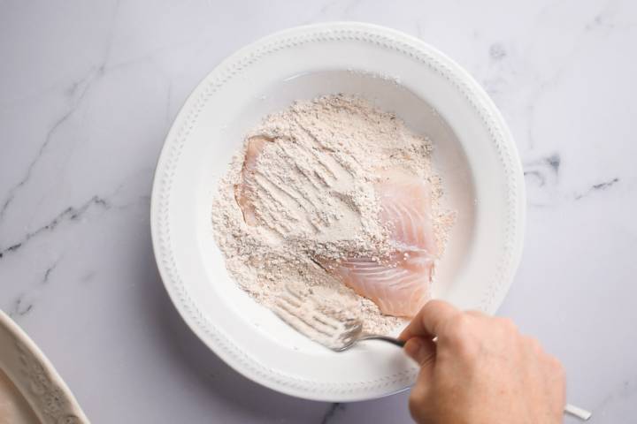 Pan Seared Cod Cod fish being dredged in flour and spices.