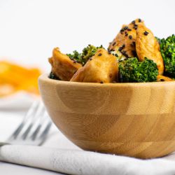 Chicken and Broccoli Stir Fry Chicken broccoli stir fry with stir fry sauce in a wooden bowl with sesame seeds.