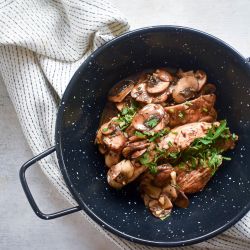 Balsamic Chicken with Mushrooms Balsamic chicken and mushrooms with fresh thyme and parsley in a bowl with a white napkin.