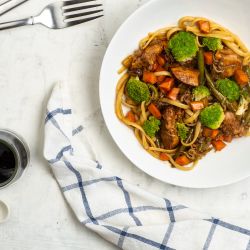 Healthy Chicken Lo Mein Healthy chicken lo mien with broccoli on a white plate with soy sauce.