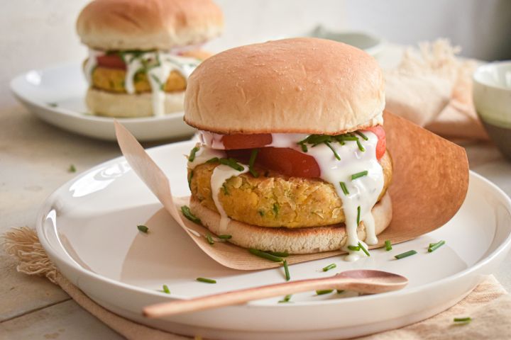 Ranch Chickpea Burgers Ranch chickpea burgers served on a bun with lettuce, tomato, and ranch dressing.