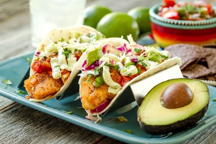 Fish Tacos and Avocado Crema Easy fish tacos with avocado cream on two corn tortillas with a fork and green napkin.