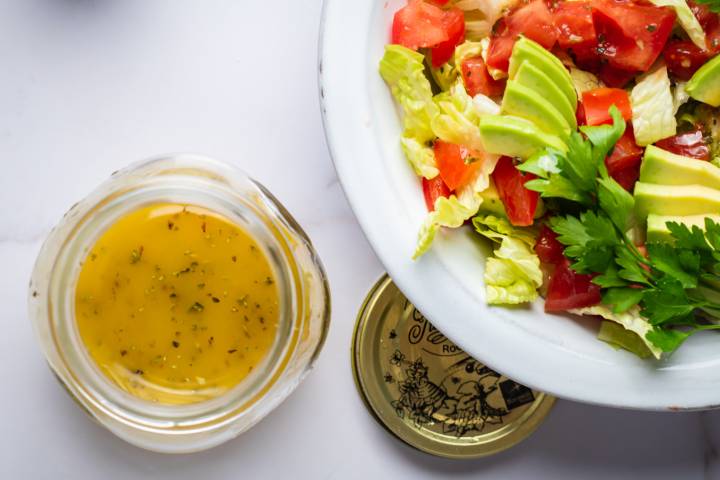 Light Italian Dressing Light Italian dressing in a jar with olive oil, vinegar, and lemon and served over a green salad.