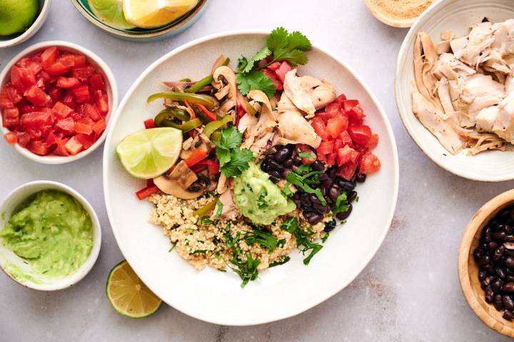 Rotisserie Chicken Taco Bowls Rotisserie chicken taco bowl with black beans, bell peppers, onions, guacamole, and tomatoes.