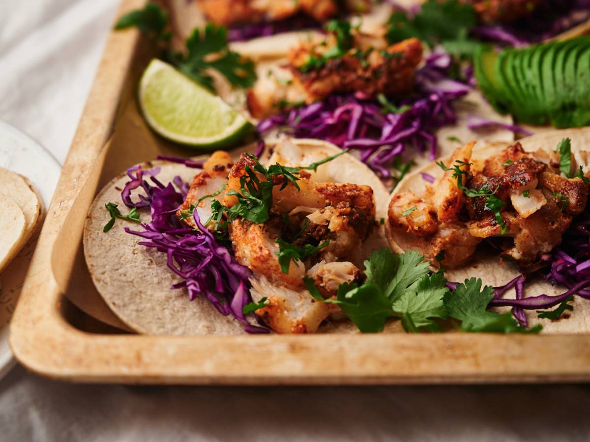 Fish, Shrimp, and Seafood Taco Recipes Fish tacos with flaky seasoned fish served in a corn tortilla with cilantro, shredded red cabbage, and limes.