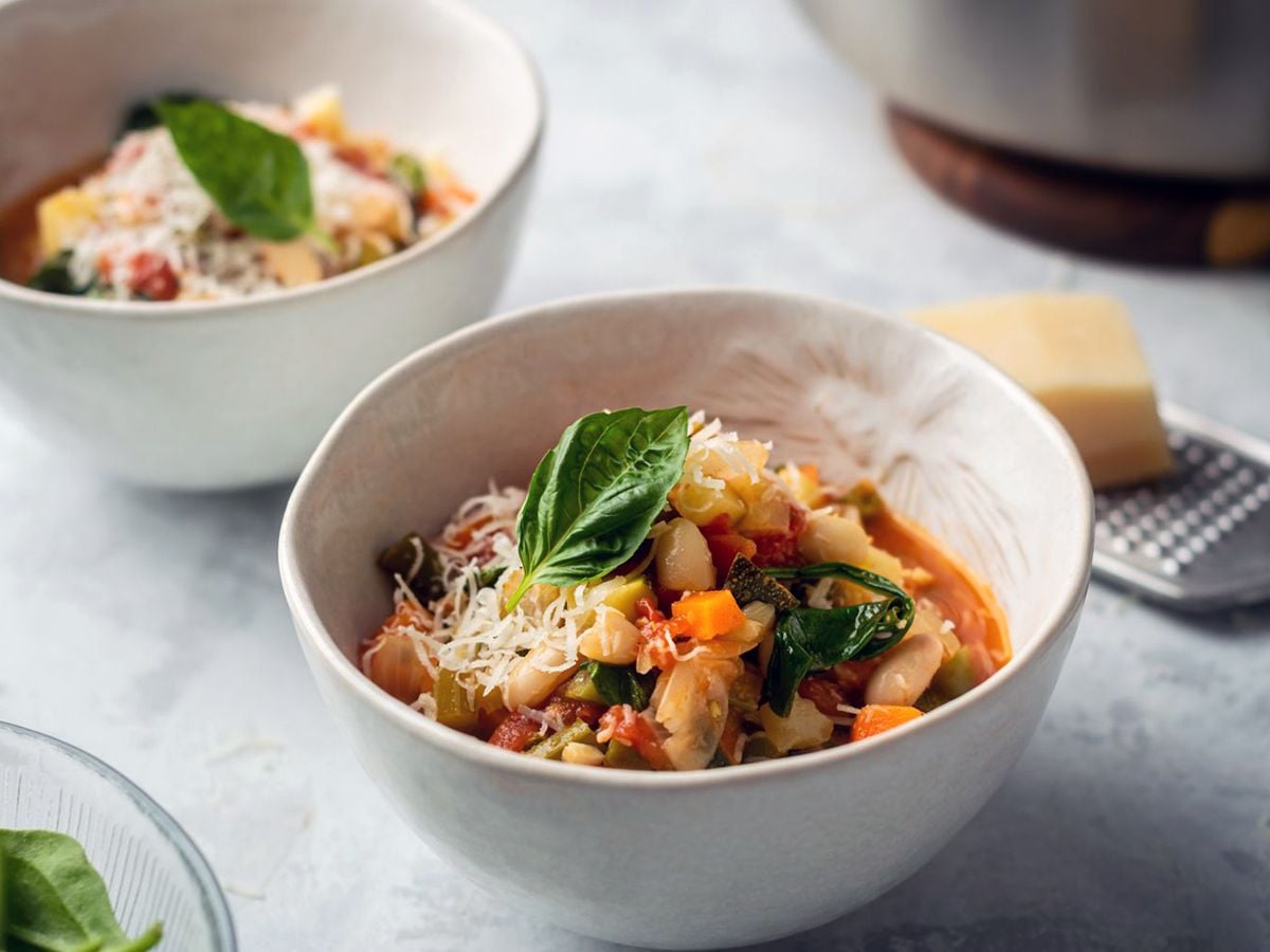 Healthy 300 Calories Recipes A Delicious Italian Vegetable and Bean Soup in a White Bowl Garnished with Basil