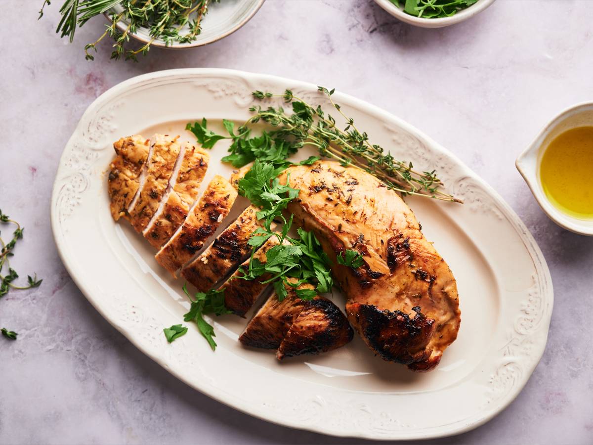 Turkey Dinners Baked turkey tenderloin sliced on a plate with fresh herbs.
