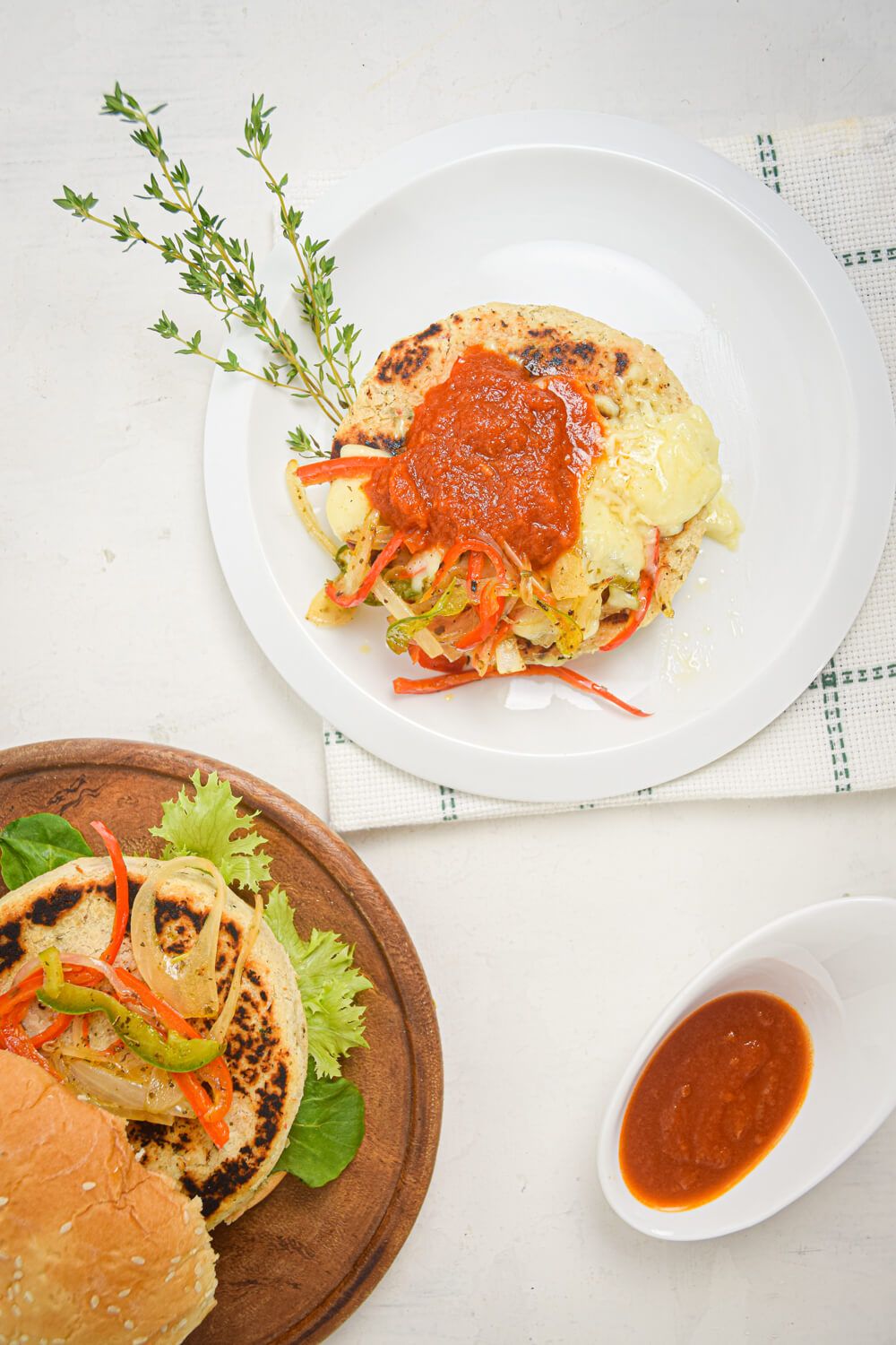 White bean vegetarian burgers with cheese, marinara sauce, peppers, and onions.