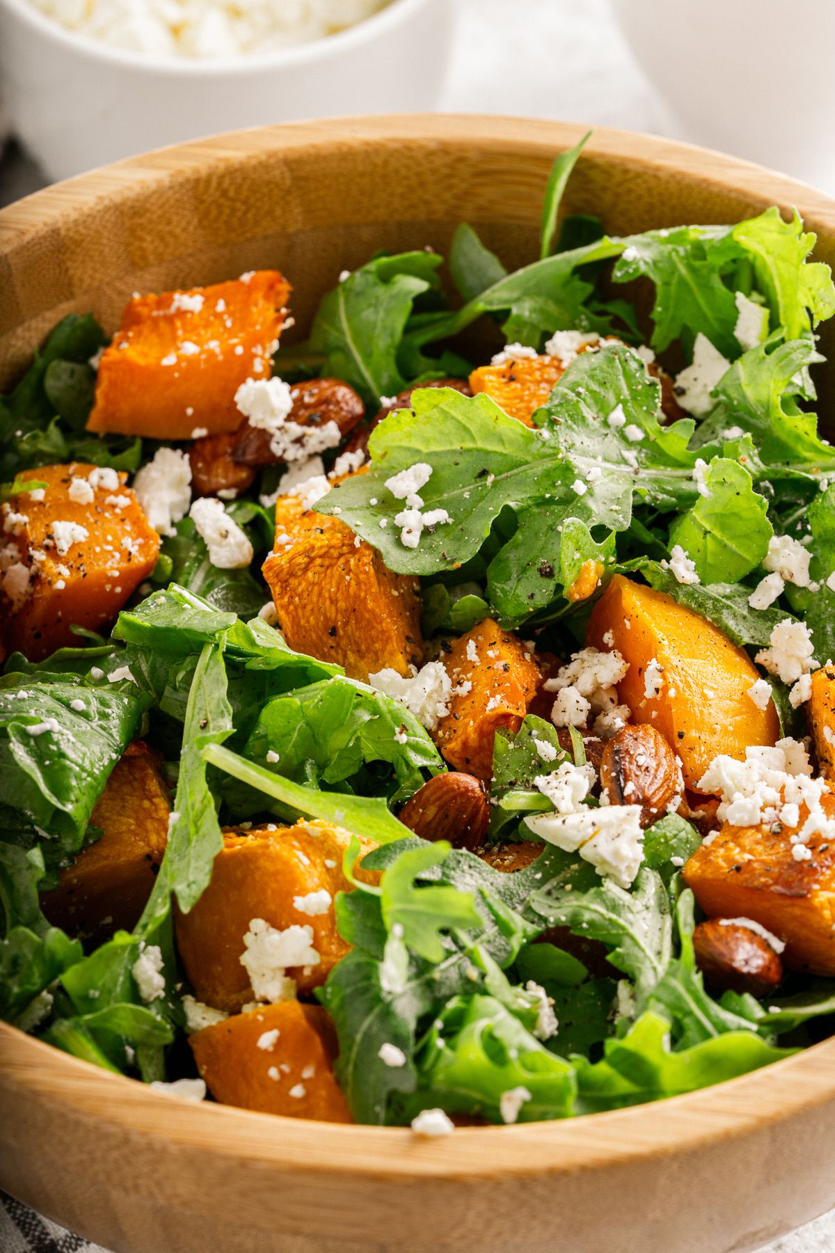 Squash salad with butternut squash, arugula, almonds, and feta cheese tossed in an orange vinaigrette.