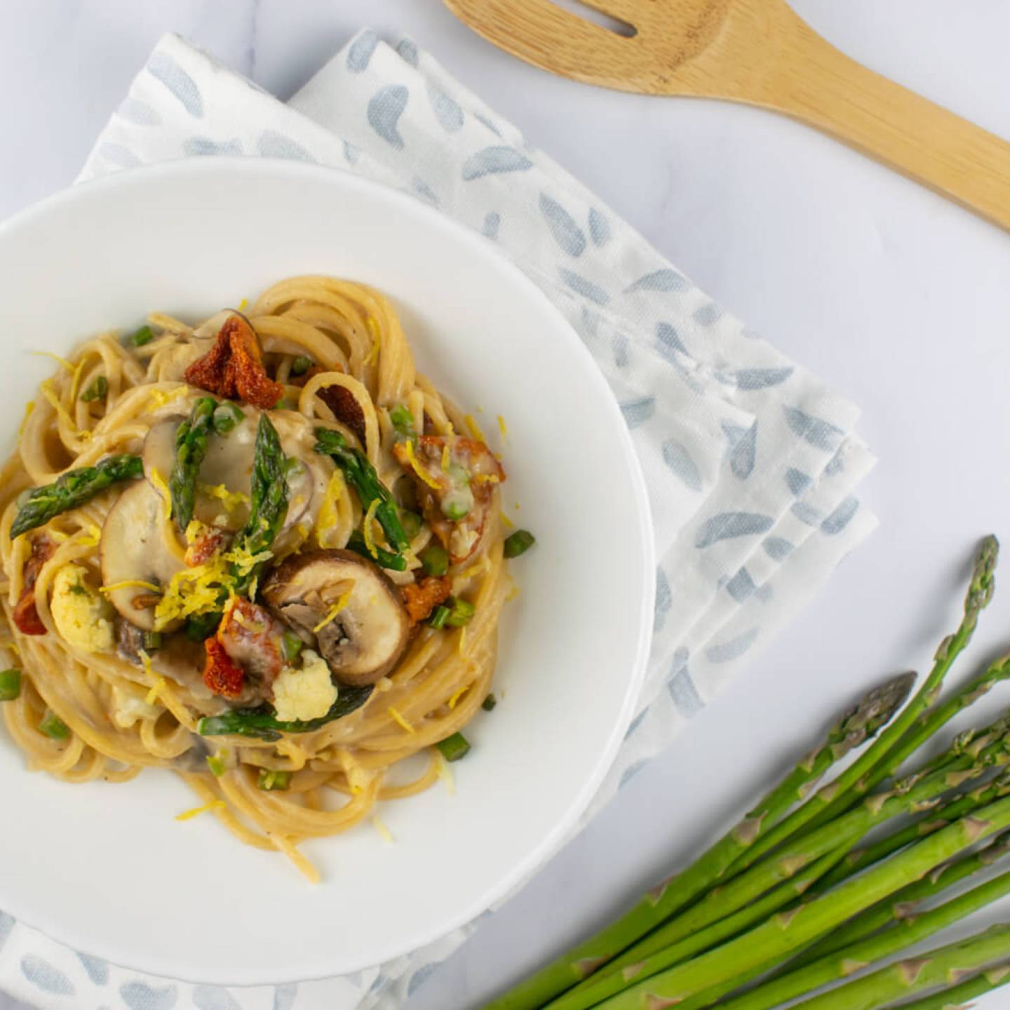 Vegetable alfredo with asparagus, mushrooms, and tomatoes in a creamy alfredo sauce.