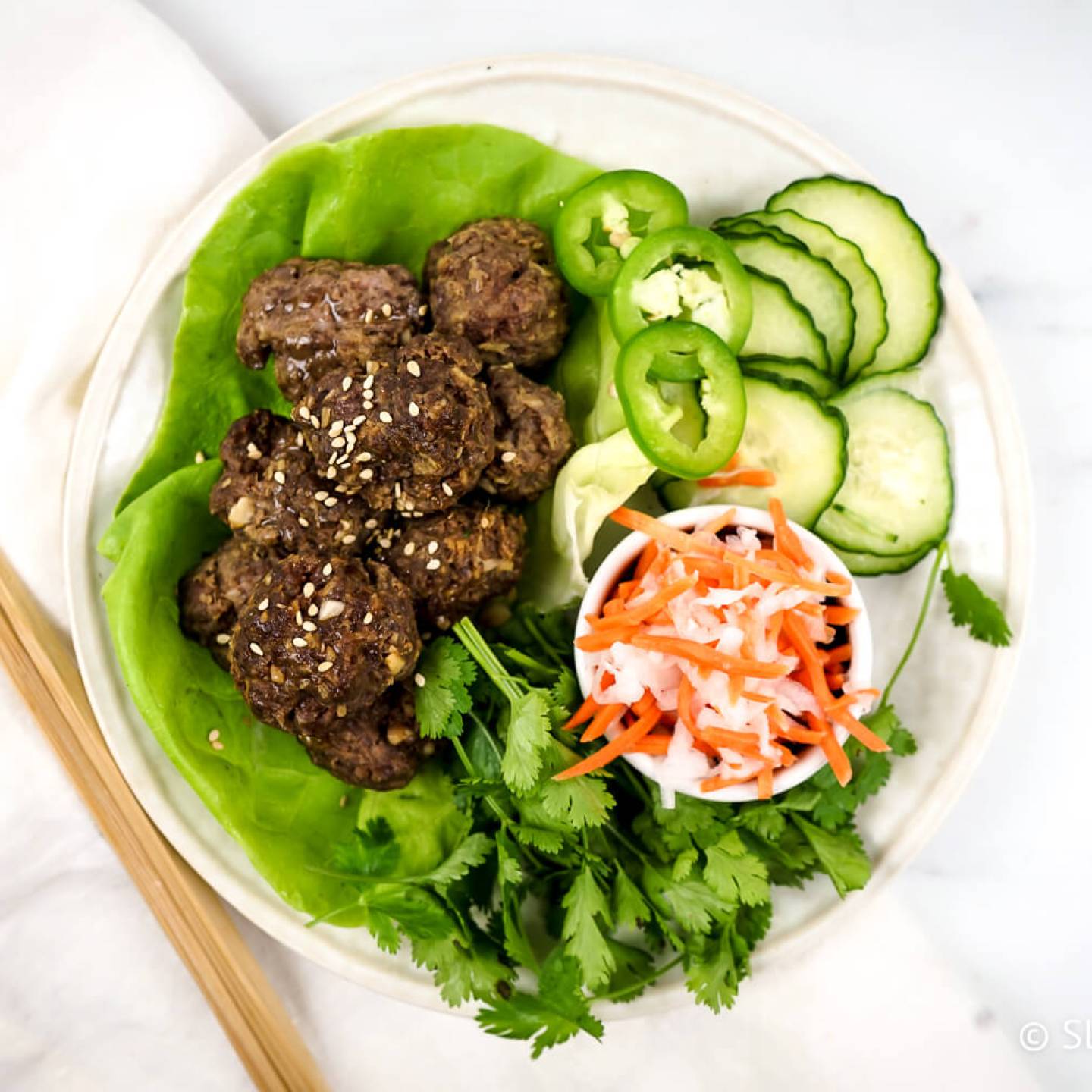 Asian meatballs with cucumbers, pickled carrots, and lettuce wraps.
