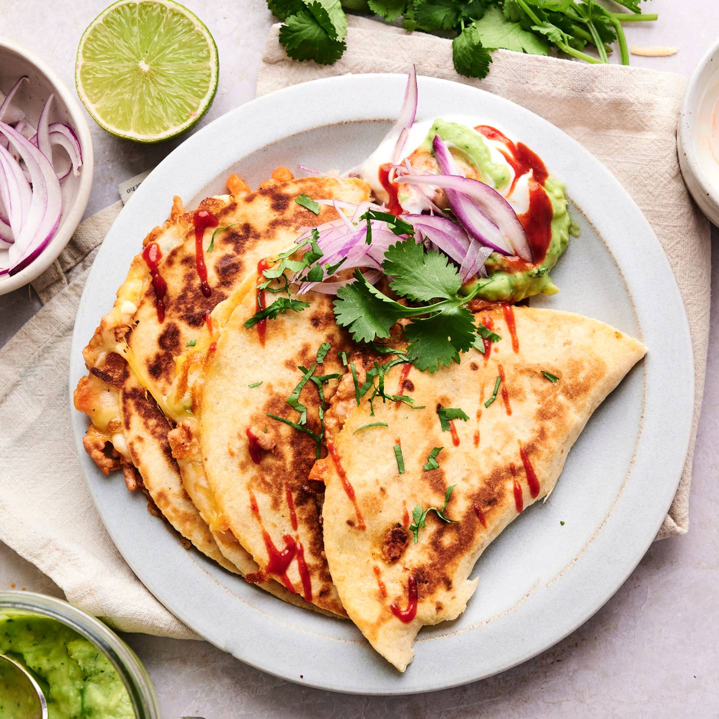 Buffalo chicken quesadillas cut into triangles with buffalo sauce drizzled on top.