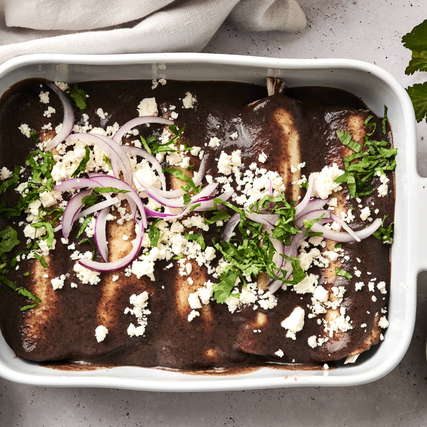 Enfrijoladas with chicken and black bean sauce in a pan ready to be served.