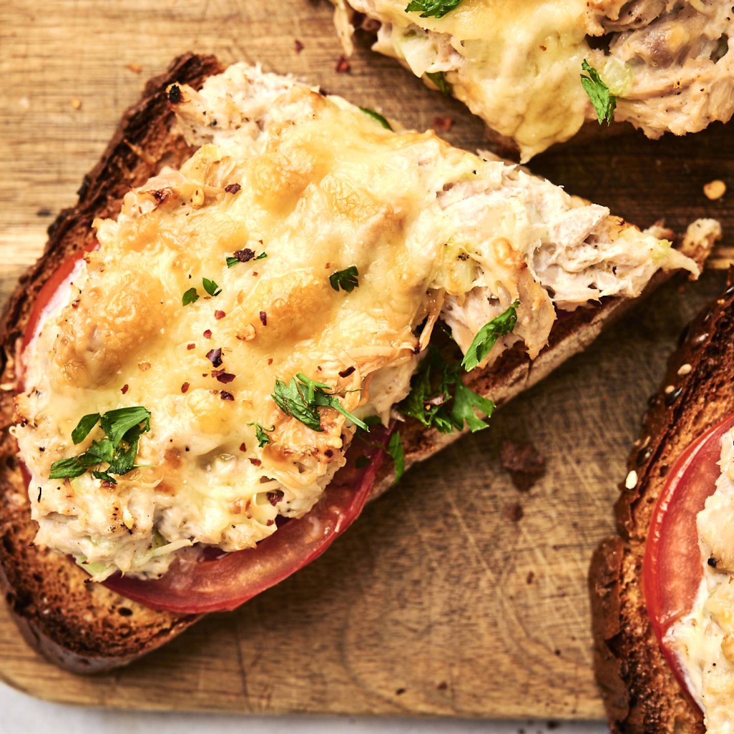 Healthy tuna melt served open faced with tomato slices and cheddar cheese.