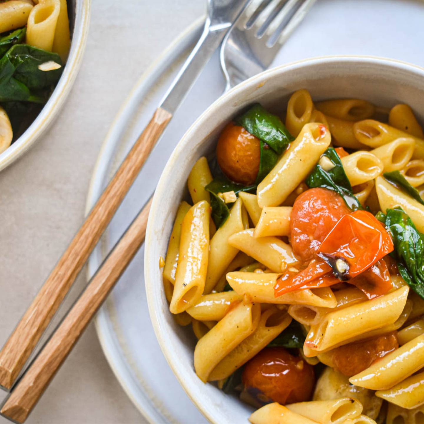 One Pot Tomato Basil Pasta in a bowl with mushrooms, spinach, and cherry tomatoes.