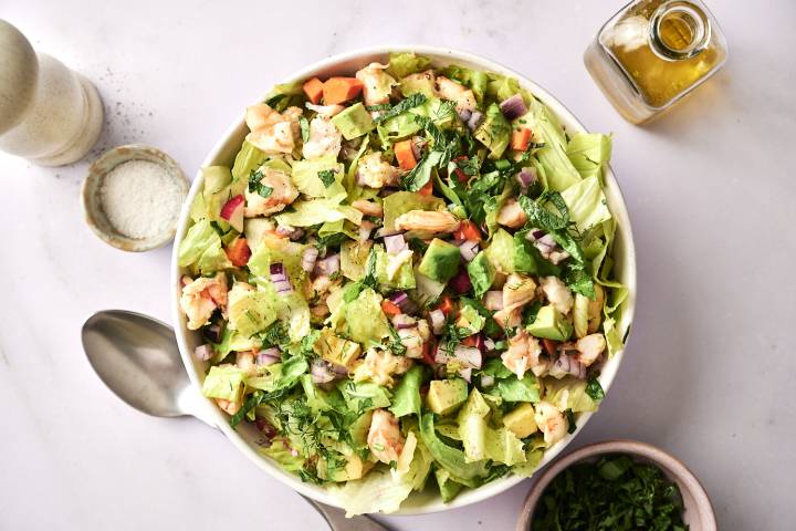 A top-down shot of a bowl of chopped shrimp salad, garnished with cilantro.