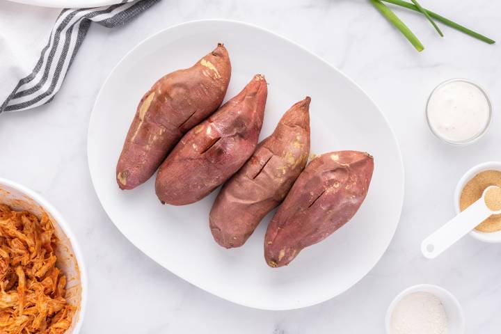 Baked sweet potatoes on a white plate.
