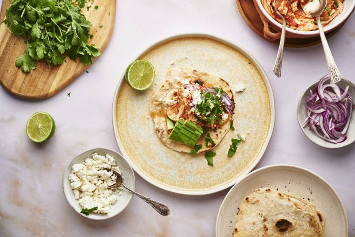 Chicken tinga taco on a tortilla with fresh cilantro, onion, and cheese.