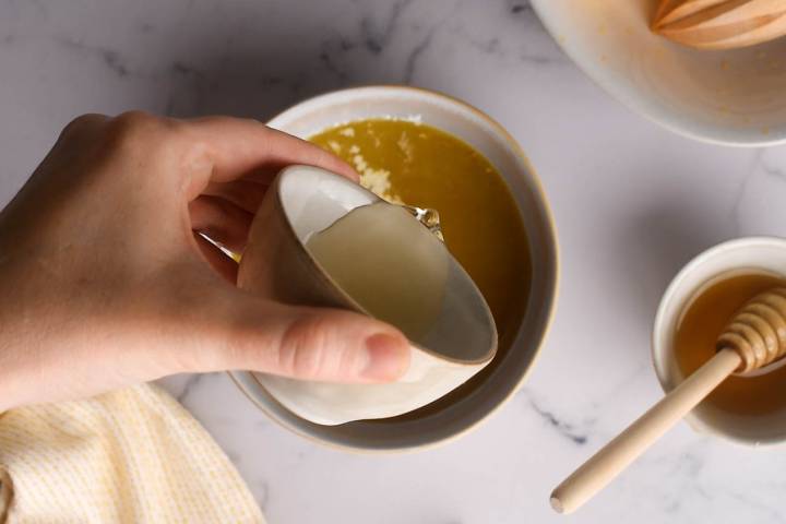 Orange sauce with honey, rice vinegar, soy sauce, garlic, and ginger in a bowl.
