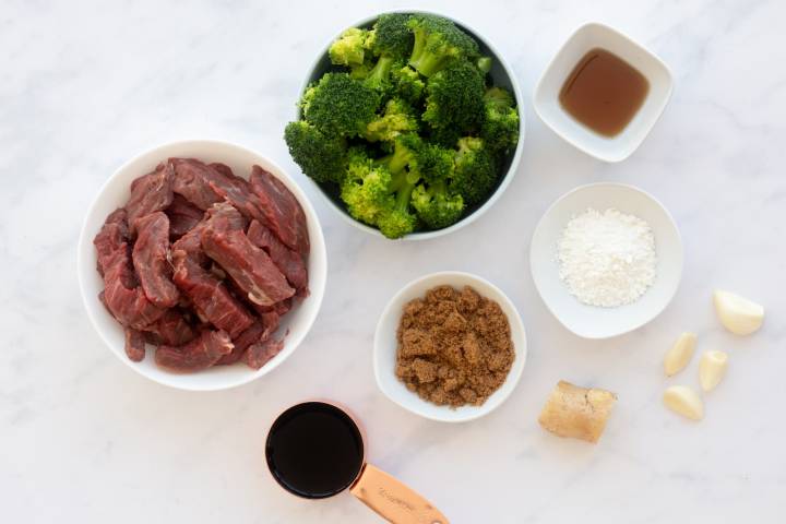 Ingredients for beef and broccoli including broccoli, flank steak, soy sauce, sugar, cornstarch, and ginger.