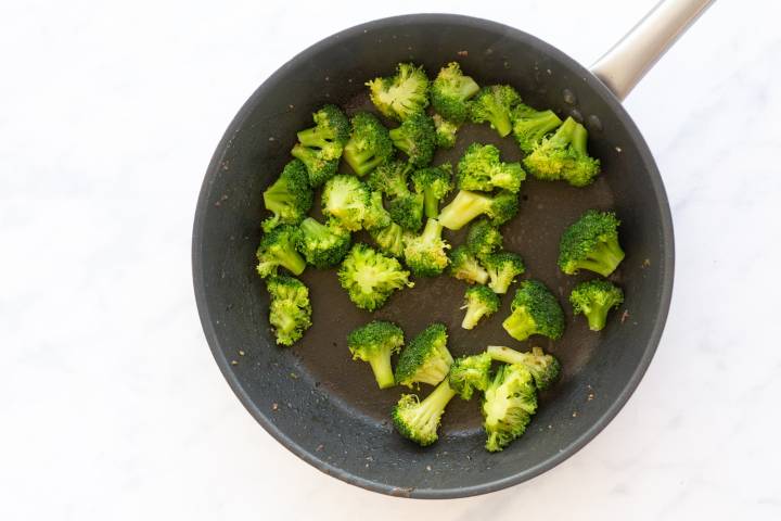 Broccoli cooking in a skillet.