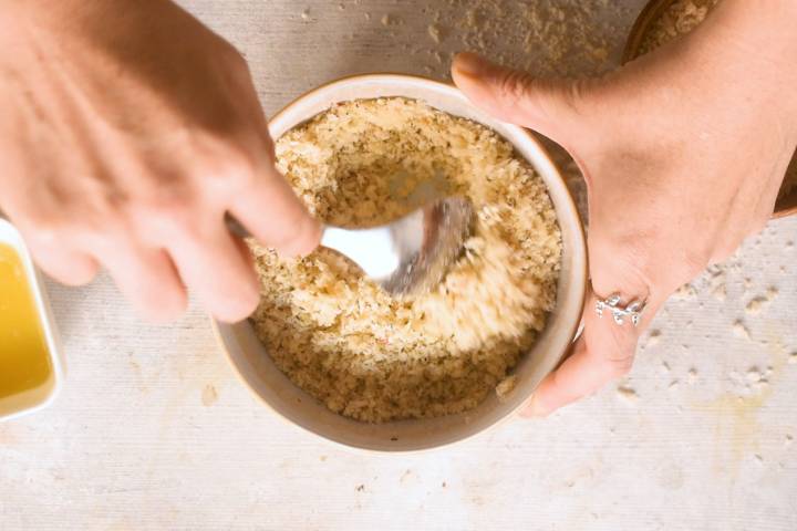 Parmesan and breadcrumb mixture in a bowl with butter.