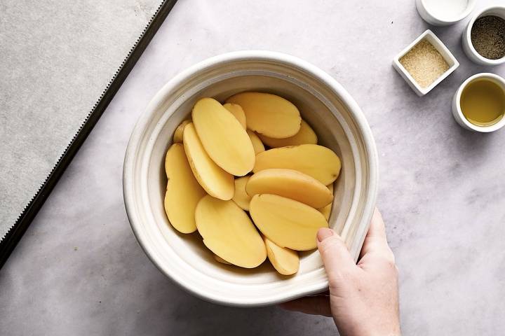 Fingerling potatoes cut in half in a white bowl.