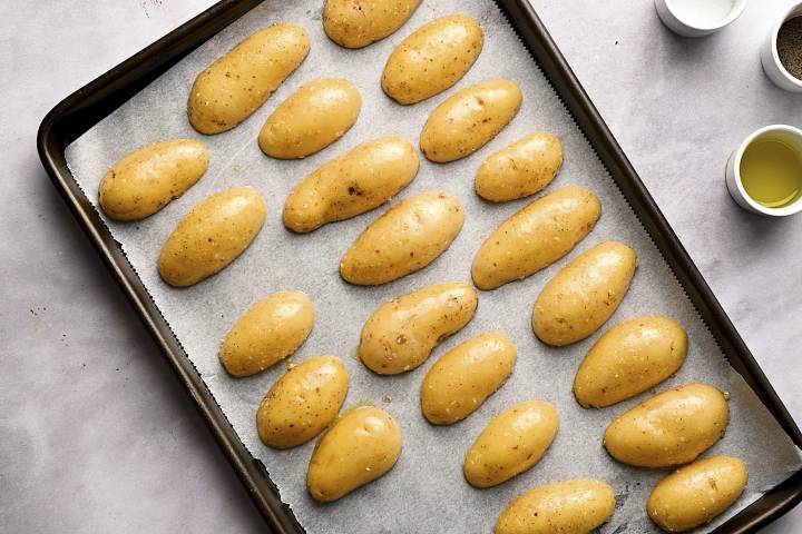 Fingerling potatoes cut in half and placed cut side down on a baking sheet.