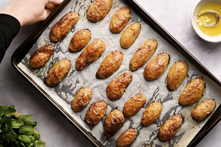 Roasted fingerling potatoes on a baking sheet covered with parchment paper.