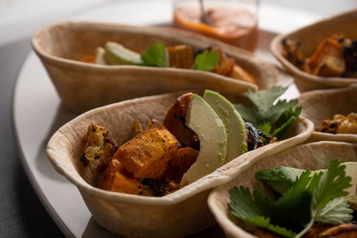 Sweet potato tacos with avocado, cilantro, cauliflower, and black beans in corn tortillas.