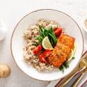 Spicy salmon with chili powder and spices cooked and served with rice and vegetables.